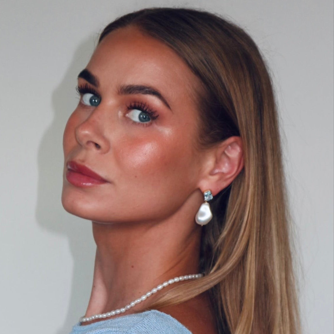 Woman in a light blue sweater with a neutral background
