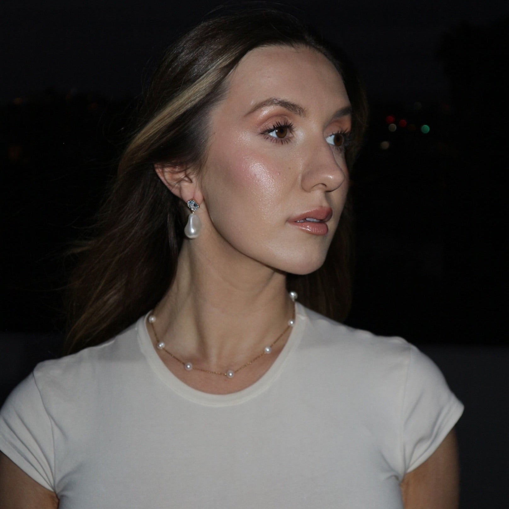 Woman wearing a white shirt with a dark background